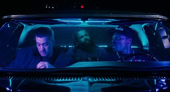 Movie still from “Blindspotting” (2018), directed by Carlos López Estrada – A group of men sitting in the back seat of a car; Medium shot, Low angle