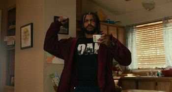 Movie still from “Blindspotting” (2018), directed by Carlos López Estrada – A man with dreadlocks holding a video game controller in his hand; Medium shot, Low angle