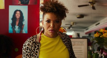 Movie still from “Blindspotting” (2018), directed by Carlos López Estrada – A person wearing a yellow shirt and leopard print jacket; Close Up shot, Low angle