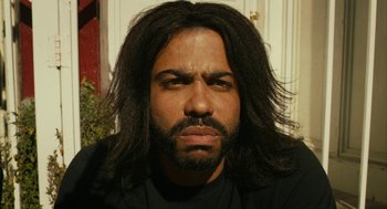 Movie still from “Blindspotting” (2018), directed by Carlos López Estrada – A person with long black hair; Close Up shot, High angle