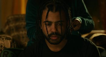 Movie still from “Blindspotting” (2018), directed by Carlos López Estrada – A person with dreadlocks; Close Up shot, Over the shoulder angle