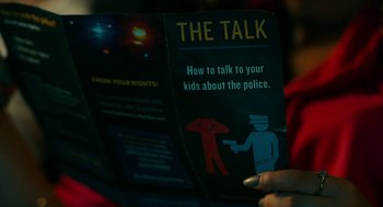 Movie still from “Blindspotting” (2018), directed by Carlos López Estrada – A person holding a pamphlet that reads " the talk "; Extreme Close Up shot, High angle