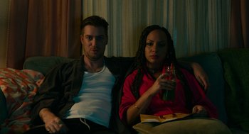 Movie still from “Blindspotting” (2018), directed by Carlos López Estrada – A man and a woman sitting on a couch; Medium shot, High angle