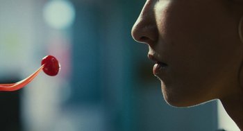 Movie still from “Blindspotting” (2018), directed by Carlos López Estrada – A woman is looking at a red object in front of her face; Extreme Close Up shot, Over the shoulder angle