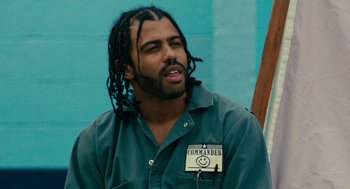 Movie still from “Blindspotting” (2018), directed by Carlos López Estrada – A man with dreadlocks is wearing a green shirt; Close Up shot, Low angle