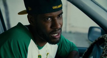 Movie still from “Blindspotting” (2018), directed by Carlos López Estrada – A person wearing a hat; Close Up shot, Over the shoulder angle