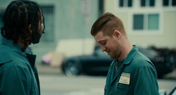Movie still from “Blindspotting” (2018), directed by Carlos López Estrada – A man with a name tag on his shirt talking to another man; Medium shot, Over the shoulder angle