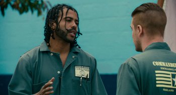 Movie still from “Blindspotting” (2018), directed by Carlos López Estrada – A man with dreadlocks talking to another man; Medium shot, Over the shoulder angle