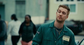 Movie still from “Blindspotting” (2018), directed by Carlos López Estrada – A man in a green shirt is walking down the street; Close Up shot, Over the shoulder angle