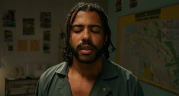 Movie still from “Blindspotting” (2018), directed by Carlos López Estrada – A person with dreadlocks wearing a green shirt; Close Up shot, Low angle
