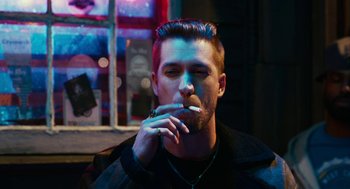 Movie still from “Blindspotting” (2018), directed by Carlos López Estrada – A man smoking a cigarette in front of a store window; Close Up shot, Over the shoulder angle