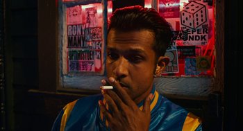 Movie still from “Blindspotting” (2018), directed by Carlos López Estrada – A man smoking a cigarette in front of a window; Close Up shot, Low angle