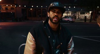Movie still from “Blindspotting” (2018), directed by Carlos López Estrada – A man wearing a baseball cap and a jacket; Close Up shot, Low angle