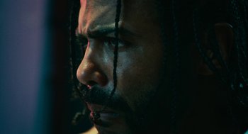 Movie still from “Blindspotting” (2018), directed by Carlos López Estrada – A person with dreadlocks; Extreme Close Up shot, Low angle