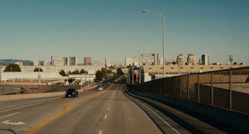 Movie still from “Blindspotting” (2018), directed by Carlos López Estrada – An empty street with a car driving down it; Extreme Wide shot, High angle
