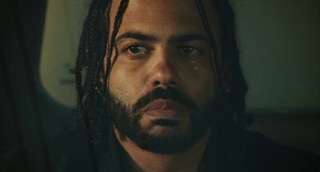 Movie still from “Blindspotting” (2018), directed by Carlos López Estrada – A person with dreads and a beard; Extreme Close Up shot, Low angle