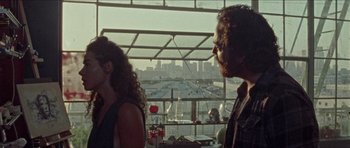 Movie still from “Bliss” (2019), directed by Joe Begos – A man and a woman standing in front of a window; Medium shot, Over the shoulder angle