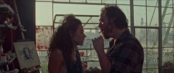 Movie still from “Bliss” (2019), directed by Joe Begos – A man and a woman looking into each others eyes; Medium shot, Low angle