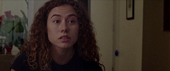 Movie still from “Bliss” (2019), directed by Joe Begos – A person with curly hair; Close Up shot, Low angle