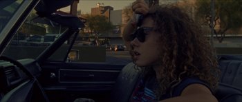 Movie still from “Bliss” (2019), directed by Joe Begos – A woman sitting in the back seat of a car; Close Up shot, High angle
