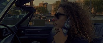 Movie still from “Bliss” (2019), directed by Joe Begos – A woman talking on a cell phone while sitting in a car; Close Up shot, Low angle