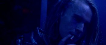 Movie still from “Bliss” (2019), directed by Joe Begos – A woman smoking a cigarette in a dark room; Extreme Close Up shot, Over the shoulder angle