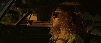 Movie still from “Bliss” (2019), directed by Joe Begos – A woman sitting in the driver's seat of a car; Close Up shot, Low angle