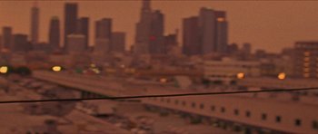 Movie still from “Bliss” (2019), directed by Joe Begos – A blurry picture of a city skyline at night; Extreme Wide shot, Low angle