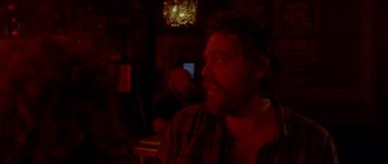 Movie still from “Bliss” (2019), directed by Joe Begos – A man sitting at a table in front of a computer screen; Close Up shot, Over the shoulder angle