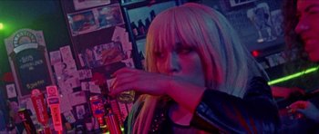 Movie still from “Bliss” (2019), directed by Joe Begos – A woman with long blonde hair is drinking a beer; Close Up shot, Over the shoulder angle