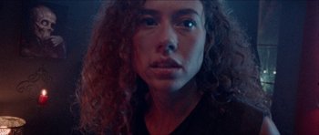 Movie still from “Bliss” (2019), directed by Joe Begos – A person with curly hair; Extreme Close Up shot, Low angle