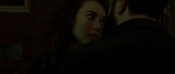 Movie still from “Bliss” (2019), directed by Joe Begos – A person with curly hair; Close Up shot, Low angle