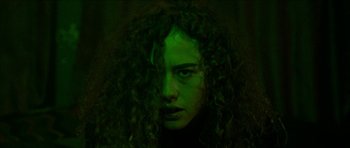 Movie still from “Bliss” (2019), directed by Joe Begos – A person with curly hair; Close Up shot, Low angle