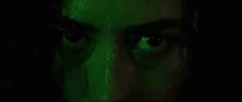 Movie still from “Bliss” (2019), directed by Joe Begos – A person's eyes lit up by green light; Extreme Close Up shot, Low angle