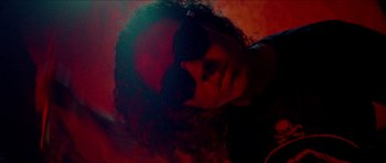 Movie still from “Bliss” (2019), directed by Joe Begos – A woman wearing sunglasses is laying on the ground; Extreme Close Up shot, Low angle
