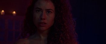 Movie still from “Bliss” (2019), directed by Joe Begos – A person with curly hair; Close Up shot, Low angle