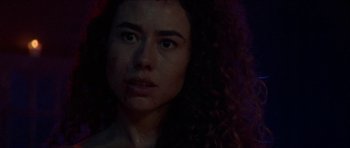 Movie still from “Bliss” (2019), directed by Joe Begos – A person with curly hair; Close Up shot, Low angle
