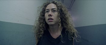 Movie still from “Bliss” (2019), directed by Joe Begos – A person with curly hair; Close Up shot, Low angle