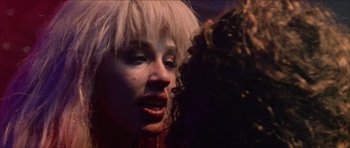 Movie still from “Bliss” (2019), directed by Joe Begos – A woman with blonde hair is crying in front of another woman; Close Up shot, Over the shoulder angle
