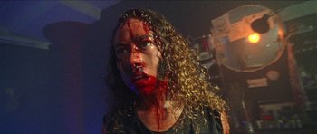 Movie still from “Bliss” (2019), directed by Joe Begos – A woman with blood all over her face; Close Up shot, Low angle