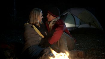 Movie still from “Blue Jay” (2016), directed by Alex Lehmann – A man and a woman sitting next to each other near a fire; Medium shot, Low angle