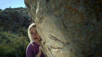 Movie still from “Blue Jay” (2016), directed by Alex Lehmann – A young woman leaning against a rock on the side of a cliff; Close Up shot, Low angle
