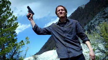 Movie still from “Blue Jay” (2016), directed by Alex Lehmann – A man holding a gun up in the air; Medium shot, Low angle
