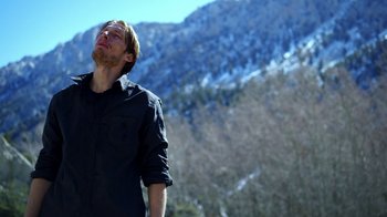 Movie still from “Blue Jay” (2016), directed by Alex Lehmann – A man standing in front of a snowy mountain; Medium shot, Low angle