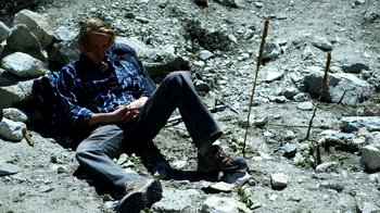 Movie still from “Blue Jay” (2016), directed by Alex Lehmann – A man sitting on the ground looking at his cell phone; Wide shot, High angle