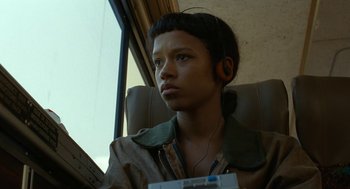 Movie still from “Bones and All” (2022), directed by Luca Guadagnino – A young man with headphones sitting in a chair; Close Up shot, High angle