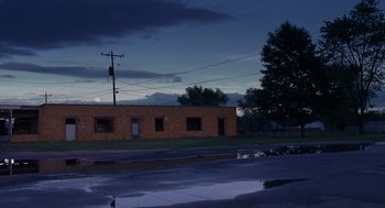 Movie still from “Bones and All” (2022), directed by Luca Guadagnino – An old brick building in the middle of the night; Extreme Wide shot, Low angle