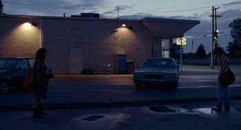 Movie still from “Bones and All” (2022), directed by Luca Guadagnino – A car parked on the side of the street at night; Extreme Wide shot, Low angle