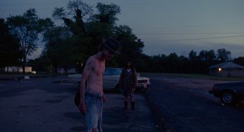 Movie still from “Bones and All” (2022), directed by Luca Guadagnino – A man and a woman walking down a street; Wide shot, Low angle