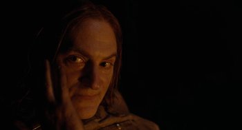 Movie still from “Bones and All” (2022), directed by Luca Guadagnino – A man with long brown hair and green eyes; Close Up shot, Over the shoulder angle